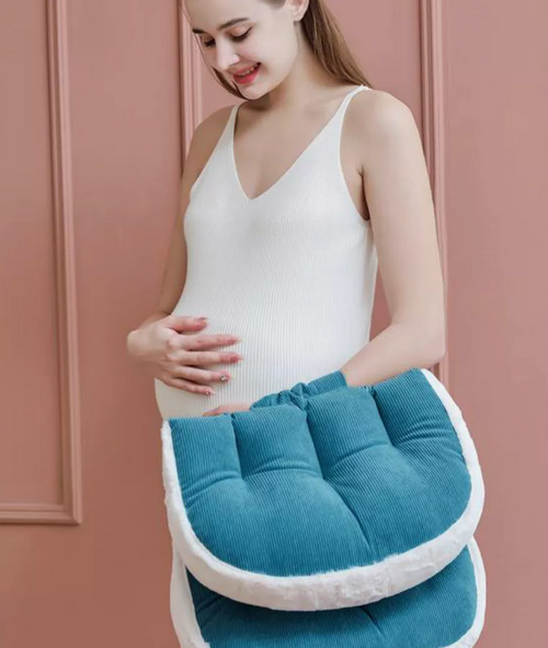 Femme enceinte tenant le coussin de grossesse Be'Cloud plié pour un transport facile et compact